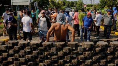 A Demontrator leans on a barricade set up during clashes with riot police yesterday night in the city of Niquinohomo, in Masaya department, about 45 km from Managua on May 7, 2018.At least four people resulted injured during fresh clashes between demonstrators and government supporters in the southern department of Masaya. The protests against Ortega erupted on April 18 and claimed at least 45 lives, according to human rights groups. / AFP PHOTO / INTI OCON