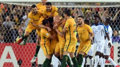 Australia's Mile Jedinak (C) is mobbed by his teammates after scoring against Honduras during their 2018 World Cup qualification play-off football match at Stadium Australia in Sydney on November 15, 2017. / AFP PHOTO / William WEST / -- IMAGE RESTRICTED TO EDITORIAL USE - STRICTLY NO COMMERCIAL USE --