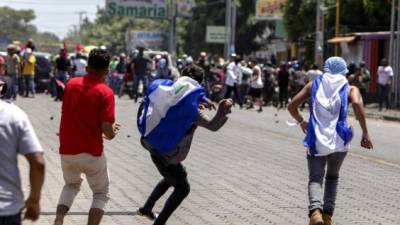 Varios jóvenes al momento de enfrentarse a las fuerzas del orden.