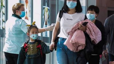 Passengers wear protective face masks as a precaution against the spread of the new Coronavirus, COVID-19, at Toncontin International Airport, in Tegucigalpa, on March 10, 2020. - Honduran Government has intensified the security on the borders and airports to prevent an eventual propagation of the new Coronavirus, COVID-19. (Photo by ORLANDO SIERRA / AFP)