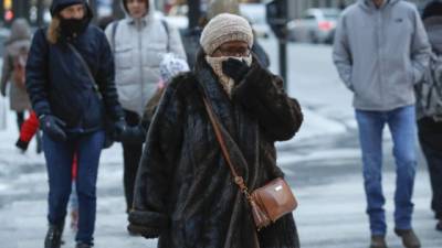 En Manhattan, las personas caminan totalmente cubiertas por las bajas temperaturas, que descenderán aún más durante el domingo y lunes.