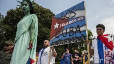 Un manifestante se viste como la Estatua de la Libertad mientras otros llevan banderas cubanas durante una manifestación frente a la Casa Blanca en Washington DC. Foto: AFP