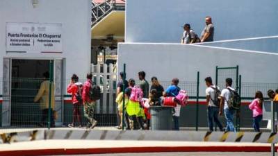 Alrededor de 40 migrantes provenientes de Centroamérica y México cruzan la línea internacional del Chaparral en Tijuana para solicitar asilo en Estados Unidos. EFE/Joebeth Terriquez/Archivo