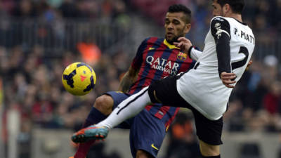 Dani Alves lucha por el balón con Pablo Piatti del Valencia.
