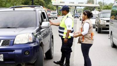 Un policía solicita la revisión a un conductor en una de las salidas de San Pedro Sula.