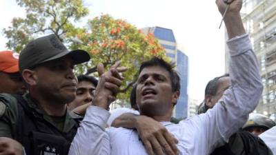 Esta foto de archivo, tomada el 18 de febrero de 2014, muestra a Leopoldo López, un ferviente oponente del gobierno socialista venezolano frente a una orden de arresto, siendo escoltado por la Guardia Nacional después de entregarse en una manifestación en Caracas el 18 de febrero de 2014./ Foto archivo AFP/ Juan BARRETO