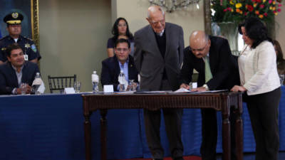 El presidente Juan O. Hernández observa la suscripción del acuerdo para la adquisición de medicinas vía fideicomiso.