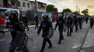 Riot police walk the streets after a demonstration against the government of President Miguel Diaz-Canel in Arroyo Naranjo Municipality, Havana on July 12, 2021. - Cuba on Monday blamed a 'policy of economic suffocation' of United States for unprecedented anti-government protests, as President Joe Biden backed calls to end 'decades of repression' on the communist island. Thousands of Cubans participated in Sunday's demonstrations, chanting 'Down with the dictatorship,' as President Miguel Díaz-Canel urged supporters to confront the protesters. (Photo by YAMIL LAGE / AFP)