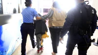 Proceso. El pequeño Wilmer sale del aeropuerto Ramón Villeda Morales junto a personal de la Dinaf. Foto: Moisés Valenzuela.