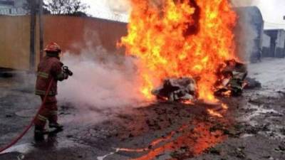 Un bombero trata de controlar el incendio provocado por la caída del aparato.