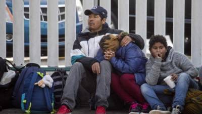 Una familia migrante espera visas humanitarias de las autoridades migratorias de los EE UU. Foto: AFP