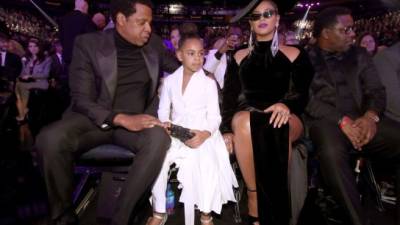 Blue Ivy (c) se sentó entre sus famosos padres Jay-Z y Beyoncé Knowles //Foto Christopher Polk/Getty Images for NARAS/AFP