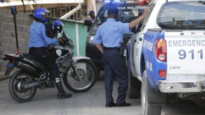 En unas dos semanas, el Congreso Nacional terminará de discutir y aprobar la nueva Ley de la Policía Nacional. En la foto, agentes patrullando en una calle de Tegucigalpa.