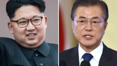 TOPSHOT - North Korea's leader Kim Jong Un (L) and South Korea's President Moon Jae-in (R) raise their jointed hands during a signing ceremony near the end of their historic summit at the truce village of Panmunjom on April 27, 2018.The leaders of South and North Korea embraced warmly after signing a statement in which they declared 'there will be no more war on the Korean Peninsula'. / AFP PHOTO / Korea Summit Press Pool / Korea Summit Press Pool