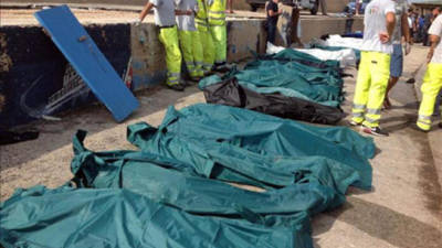 Decenas de cadáveres son cubiertos hoy en el puerto de Lampedusa en Italia. EFE