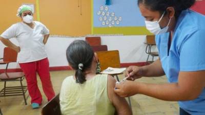 Personal de Salud inmuniza contra el covid-19 a una señora mayor de 75 años en San Pedro Sula.