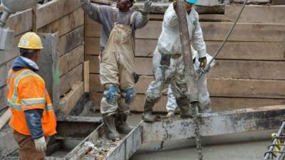 Trabajadores de la construcción vierten hormigón para hacer los cimientos de un nuevo edificio en Washington.