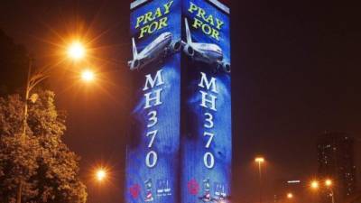 La frase 'Recemos por el MH370' se puede leer en el cartel luminoso que recubre un edificio en Kuala Lumpur, Malasia. Un avión de la aerolínea Malaysia Airlines, con destino Pekín, desapareció el 8 de marzo de 2014 con 239 personas a bordo. EFE/Archivo