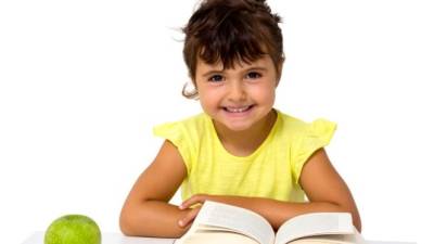 little girl reading a book with apple isolated on whitelittle girl reading a book with apple isolated on white