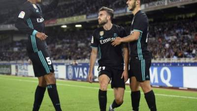 Real Madrid's forward from Spain Borja Mayoral (C) is congratulated by teammates Real Madrid's defender from France Raphael Varane (L) and Real Madrid's midfielder from Spain Marco Asensio after scoring the opening goal during the Spanish league football match Real Sociedad vs Real Madrid CF at the Anoeta stadium in San Sebastian on September 17, 2017. / AFP PHOTO / ANDER GILLENEA