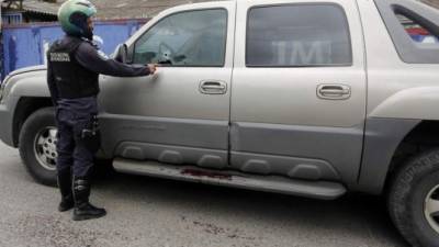 Un agente de la Policía muestra las perforaciones de bala en el carro que conducía el empresario Donaldo Alvarado.