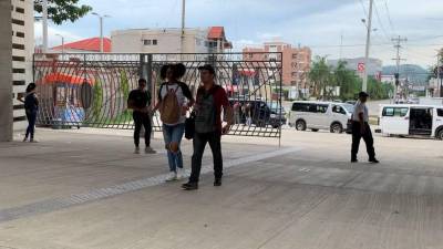 Estudiantes universitarios ingresan por el porton principal de la Universidad Nacional Autónoma de Honduras en el valle de Sula.