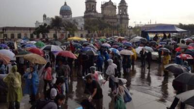 Manifestantes tuvieron que resguardarse de la lluvia.