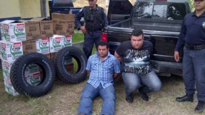 Los dos detenidos junto a la mercadería que compraron con las tarjetas clonadas.