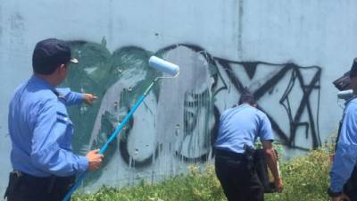 Oficiales y policías de la escala básica dejaron sus armas por brochas para borrar grafitis de maras y pandillas.