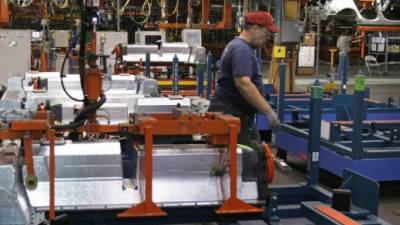 Un operario verifica la maquinaria de industria textil en una empresa estadounidense.