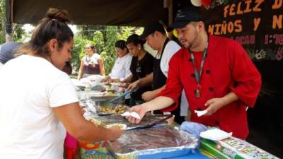 Axcel Viana, con chaqueta roja, y otros chef amigos suyos reparten alimentos en una zona de escasos recursos.