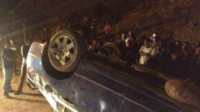 El vehículo en el que se conducían las víctimas terminó volcado con las llantas hacia arriba.