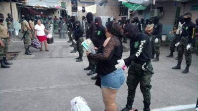 Policías militares registran a los reclusos que serán trasladados a otros centros penales del país.