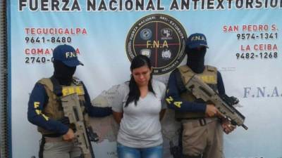 La joven de 20 años es custodiada por dos agentes de la Fuerza Nacional Antiextorsión (FNA).