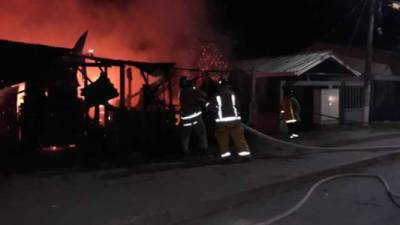 El momento cuando el personal del Cuerpo de Bomberos controlaba el incendio en el taller de mecánica en Puerto Cortés.