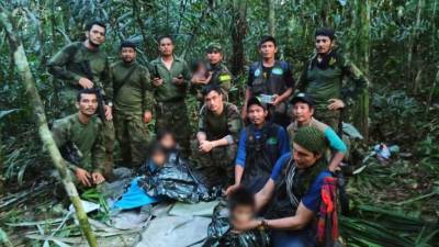 Los niños colombianos junto a un grupo de militares que logró rescatarlos tras una búsqueda de más de un mes.