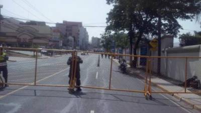 Un policía pone un candado para unir vallas.