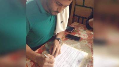 El jugador del Olimpia, Noel Valladares, firmando para validar la consulta del Partido Nacional de Honduras sobre el tema de la reelección presidencial.