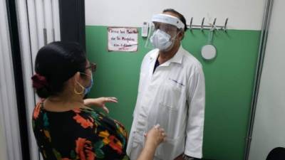 El doctor Cándido Mejía atiende a una paciente en la cabina de fototerapia para tratamiento de la enfermedad.