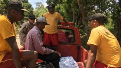 Rescatistas del Cuerpo de Bomberos transporta el cuerpo de una de las víctimas.