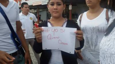 Una estudiante porta una hoja de papel pidiendo el retorno a clases.