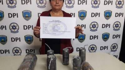 La detenida junto con los artefactos explosivos que le fueron decomisados.