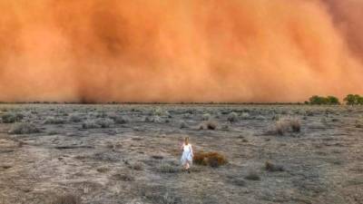 TOPSHOT - This handout photo taken on January 17, 2020 and received on January 20 courtesy of Marcia Macmillan shows a child running towards a dust storm in Mullengudgery in New South Wales. - Dust storms hit many parts of Australia's western New South Wales as a prolonged drought continues. (Photo by Handout / Courtesy of Marcia Macmillan / AFP) / RESTRICTED TO EDITORIAL USE - MANDATORY CREDIT 'AFP PHOTO / Courtesy of Marcia Macmillan' - NO MARKETING NO ADVERTISING CAMPAIGNS - DISTRIBUTED AS A SERVICE TO CLIENTS --- NO ARCHIVE ---