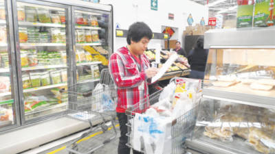 Un trabajador de Wal-Mart revisa una lista de abarrotes en Ciudad de México