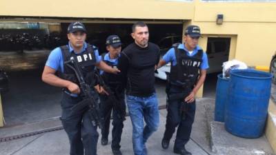 Los agentes de la DPI trasladan al supuesto cabecilla de la banda de robacarros.