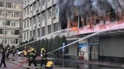 Bomberos chinos apagan las llaman del incendio en el internado.