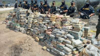 Imagen de reparto difundida por la Policía Militar de Orden Público (PMOP) que muestra a miembros de la Agencia Técnica de Investigación Criminal (ATIC) custodiando tres mil kilos de cocaína. AFP