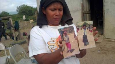 Una mujer muestra la imagen de dos pequeños que fueron asesinados en Honduras.