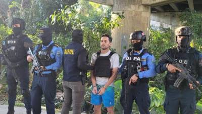 Fotografía de Jorge Luis Aguilar custodiado por agentes de la Policía, instantes después de su captura, el 8 de febrero de 2024 en San Pedro Sula, Honduras.