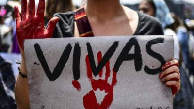 A Mexican woman holding a sign reading 'We want us alive' takes part in a protest against murders and other violence towards women in Mexico City on September 17, 2017. The protest was triggered by the murder of 19-year-old Mara Castilla, who was allegedly killed by a taxi driver on September 8, in the southern state of Puebla. / AFP PHOTO / RONALDO SCHEMIDT